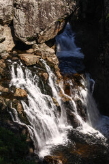 Obraz premium Waterfall in the mountains, water flowing over the rock