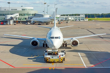 Departure of a passenger commercial flight, push back from the gangway to start engines and taxi for take off.