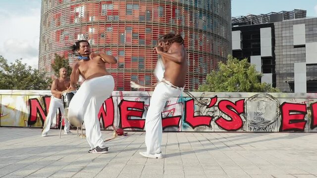 two Brazilian dancers dancing to the rhythm of capoeira