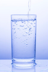 water pouring into glass on white background