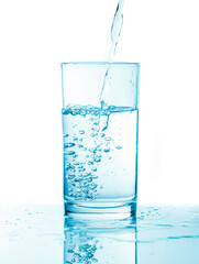 Pouring water into glass in blue toning