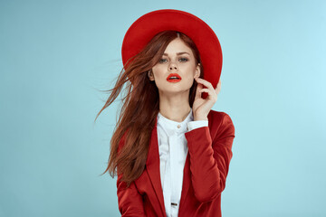 Beautiful woman in red hat jacket red lips long hair charm blue background