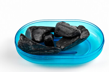 Czarne, pokruszone kawałki mydła.