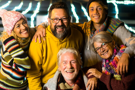 Happy caucasian people family celebrate new year eve together having fun - cheerful mied generations years age enjoying party by night in winter