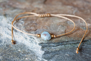 Larimar gemstone natural beads bracelet on grey rocky background