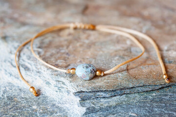 Larimar gemstone natural beads bracelet on grey rocky background