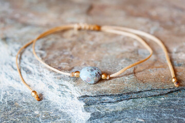 Larimar gemstone natural beads bracelet on grey rocky background