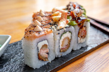 Assorted sushi rolls on wooden table