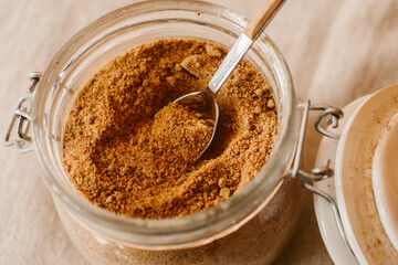 Panela sugar background. Close up view of raw cane sugar in a jar.	