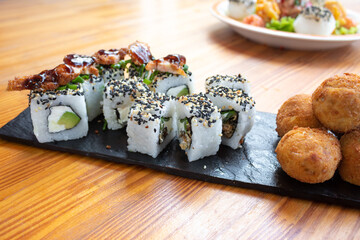 sushi roll on a black plate on a wooden table