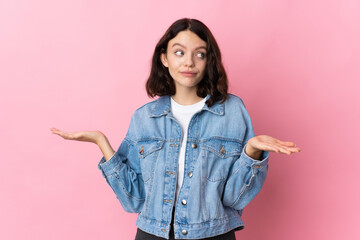 Teenager Ukrainian girl isolated on pink background making doubts gesture