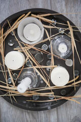amulet on a dark tray among white candles and spikelets of wheat