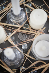 amulet on a dark tray among white candles and spikelets of wheat