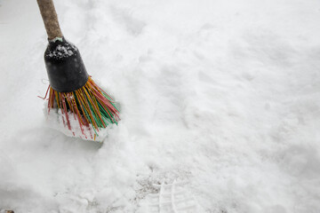 A broom in the snow. Snow removal in winter. a broom sweeps the snow for prevention.