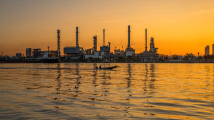 Obraz premium Oil refinery and sunrise at the Chao Phraya River, Thailand, petrochemical Industrial, oil refinery and oil industry, Sep 27, 2018.