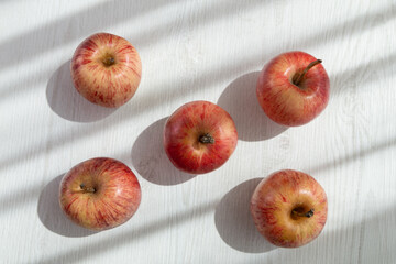 delicious fresh red apples in rows with a white background, design in a studio, healthy lifestyle