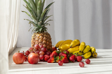 delicious fresh fruits , pineapple,  apple, strawberry, grapes and bananas, with curtain in the background, healthy lifestyle, studio style