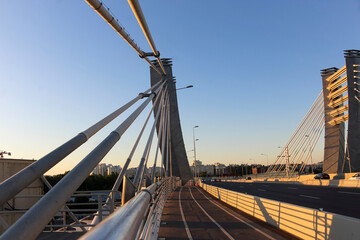 Fototapeta na wymiar Cable bridge with arched pylons. View from the point of attachment of ropes to the bridge
