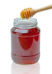Honey dripping from a honey dipper in a glass cup