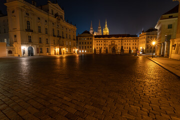 Obraz premium lit street light in a city street at night. glowing lamp at night in the old town of prague in the czech republic and in the background the view of the city of Prague at night and the 