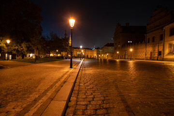  lit street light in a city street at night. glowing lamp at night in the old town of prague in the czech republic 
and in the background the view of the city of Prague at night and the 
