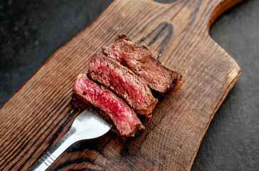three types of frying steak on a meat fork on a stone background