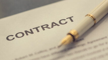A  contract and a pen on the desk.  Agreement. Fountain pen on the table. Image in Vintage style.
