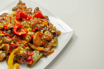 Cooked marinated beef slices with a savory black beef sauce, peppers and onions