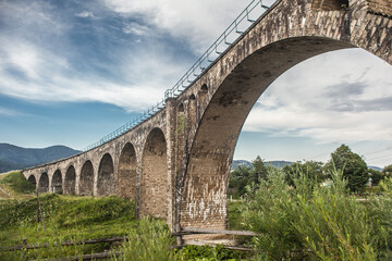 Fototapeta na wymiar landscape, old railway bridge on a background of mountains