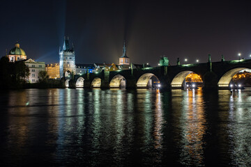 
street lights and light from him on the Charles Bridge from the 14th century on the Vltava river...