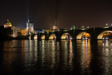 Fototapeta na wymiar street lights and light from him on the Charles Bridge from the 14th century on the Vltava river and reflections of the world in the sky and the river