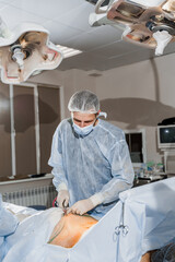 Surgeon removes fat in the gluteal region. Abdominoplasty - plastic operation to reduce the abdomen...