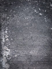 The grunge background of the gray stucco cement wall that is patterned with a rough texture.