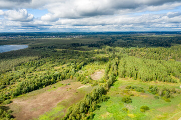 Fototapeta na wymiar Aerial view of the countryside and a circular lake in the middle of the forest.