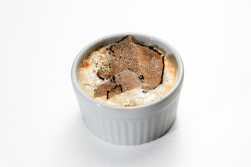 Baked egg and Fontina Cheese fondue with sliced truffle in a cocotte, isolated on white