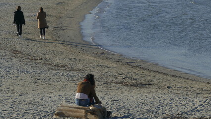 Ragazza seduta in riva al mare