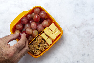 Food in Plastic containers ready to eat with Cheese, grapes and nuts