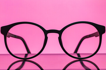 Round eyeglasses on a pink background. Fashionable round computer glasses.