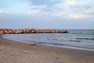 Rompeolas y playa Reyna de Constanta, Rumanía. Puesta de sol en un día frío de verano en una...