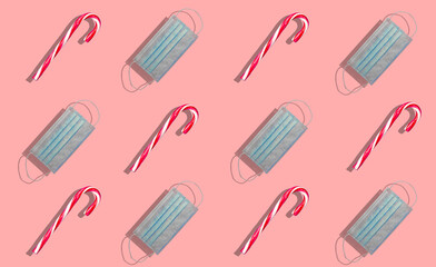 Merry Christmas candy in series along with a medical facial mask representing Christmas with covid and coronavirus. Christmas and covid concept.