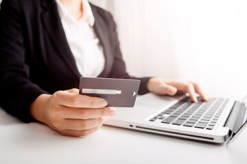 Fototapeta premium businesswoman hand using smart phone, tablet payments and holding credit card online shopping, omni channel, digital tablet docking keyboard computer at office in sun light