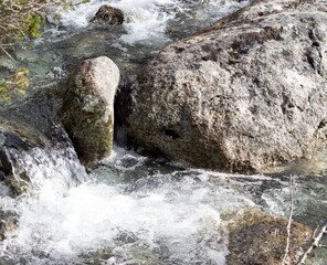 In summer, the rocky mountains have a stormy mountain river