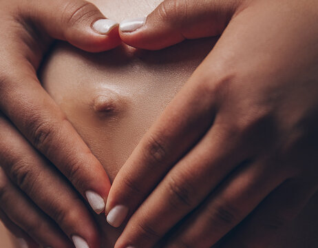 Pregant woman is holding belly with hands