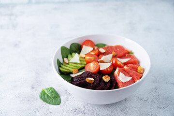 Red grapefruit beet spinach tomato salad in a bowl