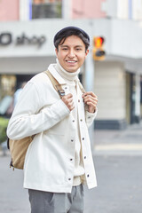 Stylish man walking down the street wearing white  sweater and jacket laughing on street
