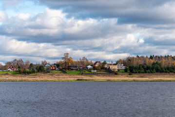 Fototapeta na wymiar Village by the river. Rural autumn landscape.