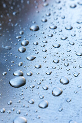 Water drops on a metal surface, background, shallow depth of field.