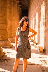 Portrait of a young brunette on the columns of the Edfu Temple near the city of Aswan. Egypt, west...