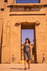 Fototapeta na wymiar A young tourist leaving the Edfu Temple near the Nile River in Aswan. Egypt