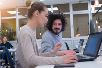 Portrait of two busymale and female  colleagues working on pc economy project on modern workplace startup.